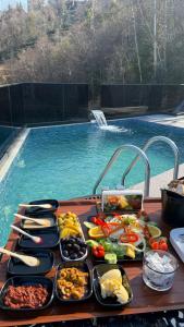 a buffet of food on a table next to a swimming pool at Loya Butik Otel Bungalov in Rize