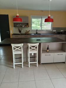 a kitchen with a counter and two stools in it at L'Airial du moulin in Parentis-en-Born