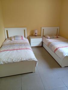 two beds sitting next to each other in a bedroom at L'Airial du moulin in Parentis-en-Born
