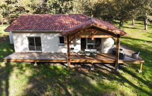 a house with a wooden deck in the grass at L'Airial du moulin in Parentis-en-Born +9 photos