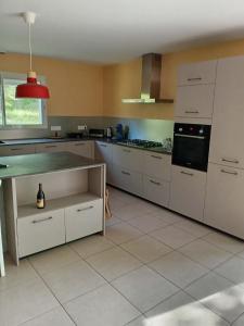 a kitchen with white cabinets and a counter top at L'Airial du moulin in Parentis-en-Born
