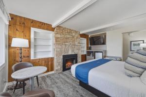 a hotel room with a bed and a fireplace at The Water Street Inn in Ephraim