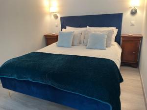 a bedroom with a large bed with blue sheets and pillows at Gîtes de Montcabirol - Malepère in La Bastide-de-Bousignac