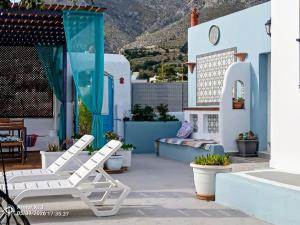 a patio with two white chairs and a table at Kareshome-Privacy-view in Kalymnos