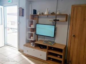 a television on a wooden stand in a room at Kareshome-Privacy-view in Kalymnos