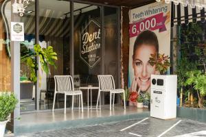 a store with chairs and a table in front of it at Dent Station Residence in Ban Suan