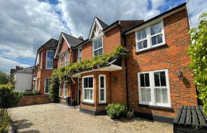 a brick house with white windows and ivy at Wisteria House Boutique Stay Marlow in Marlow