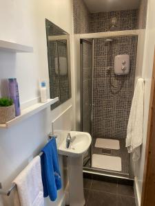 a bathroom with a sink and a shower with blue towels at The Blue Lodge in Galway +20 photos