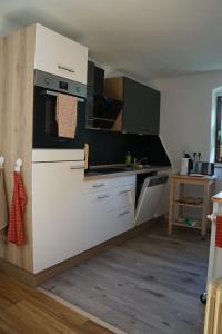 a kitchen with white cabinets and a stove top oven at Landidyll Am Eisenberg in Kirchberg