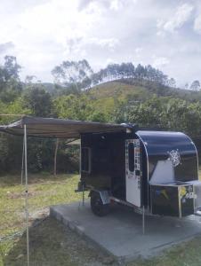 a black trailer with a tent in a field at Be Happy Park Piracaia in Piracaia +61 photos