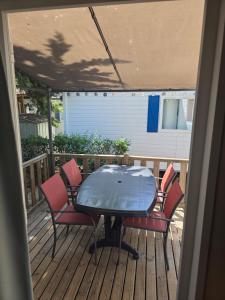 a patio table and chairs on a deck at Vias Plage - Camping Les Salisses - Mobilhome in Vias +50 photos