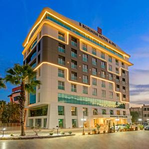 ein Hotelgebäude mit einer Palme davor in der Unterkunft B Business Hotel & Spa in Antalya