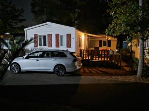 a white car parked in front of a house at Vias Plage - Camping Les Salisses - Mobilhome in Vias