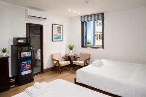 a hotel room with two beds and a television at Khách Sạn Cát House in Ha Long