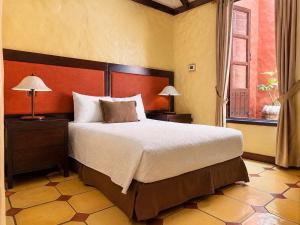 a bedroom with a large bed and a window at Hotel 1915 INN & SUITES in Alajuela