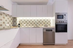 a kitchen with white cabinets and a microwave at Cavallers Suites - Unik Vacation in Tarragona