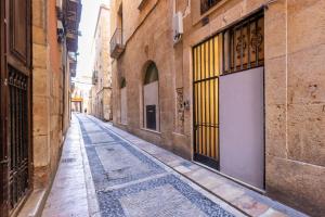 an empty street in an alley with a yellow door at Cavallers Suites - Unik Vacation in Tarragona +47 photos