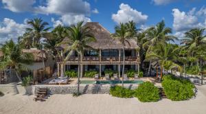 an exterior view of a resort with a pool and palm trees at Beachfront Villa Soliman Bay- 8 bedrooms in Balcheil