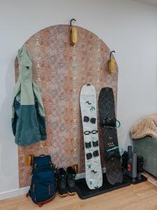 a wall with two snowboards and a bag at Private Boho Tiny Home - Lakes, Wineries, Hike, Ski in Kelowna