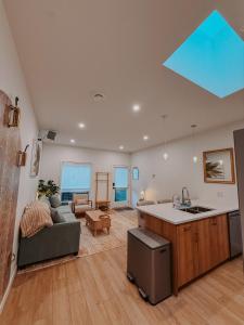 a kitchen and living room with a couch and a table at Private Boho Tiny Home - Lakes, Wineries, Hike, Ski in Kelowna