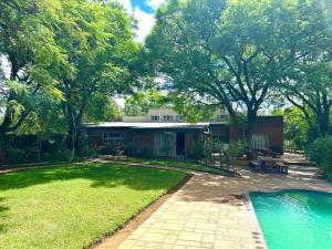 a house with a swimming pool in the yard at Kameeldoring Guesthouse in Zeerust
