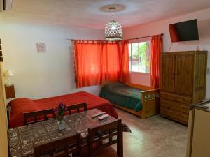 a bedroom with a bed and a table with a tableablish at Posada del Guardián in Villa Yacanto