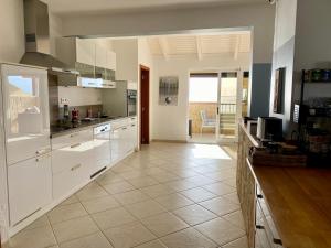 a kitchen with white cabinets and a tile floor at Seaview Luxury Penthouse Mare in Sal Rei
