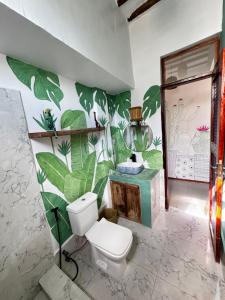 a bathroom with a toilet and a plant wall at FURAHA GARDEN Rooms in Kendwa
