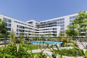 an apartment building with a swimming pool and trees at Cozy Getaway Sector 1 in Bucharest