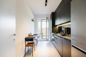 a kitchen with black and white cabinets and a table at Cozy Getaway Sector 1 in Bucharest