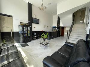 a lobby with black leather couches and a staircase at Hotel Ejecutivo 63 In in Bogotá +8 photos