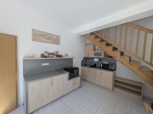 a kitchen with a stairway and a kitchen with a counter at Apartman Amanda in Poděbrady