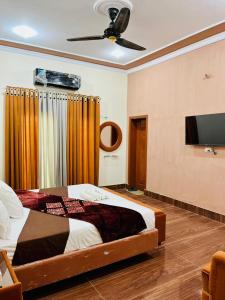 a bedroom with a bed and a flat screen tv at Hotel Multan Avenue Multan in Multan