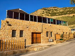 a stone building with windows on the side of a hill at DANA First View Hotel in Dana