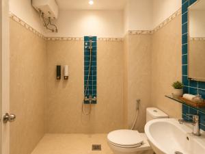 a bathroom with a shower and a toilet and a sink at Salyna Motel in Danang