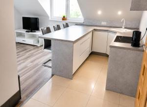 a kitchen with a counter with chairs and a tv at Apartmán Urban Kubín in Dolný Kubín +15 photos