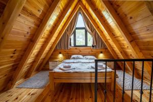 a bedroom in a log cabin with a bed in it at Zov planine in Žabljak