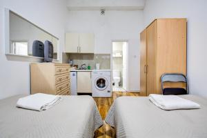 a room with two beds and a kitchen with a washing machine at The Brompton Residence Hotel in London +30 photos