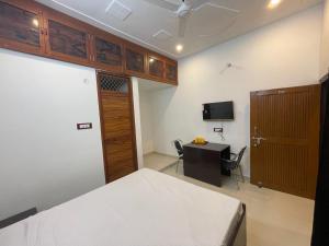 a bedroom with a bed and a desk and a television at Govind atithi greh in Ayodhya +17 photos