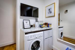 a laundry room with a washer and dryer at The Brompton Residence Hotel in London