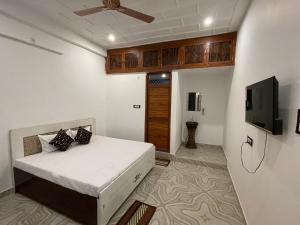 a bedroom with a bed and a flat screen tv at Govind atithi greh in Ayodhya
