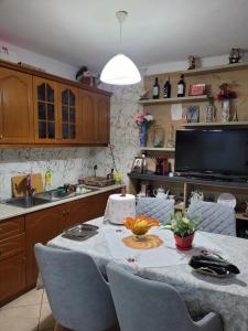 a kitchen with a table with chairs and a tv at Geri Apartment in Ksamil