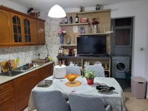a kitchen with a table with chairs and a television at Geri Apartment in Ksamil +11 photos
