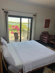 a bedroom with a large bed and a balcony at Chez Diarra in Saint-Louis