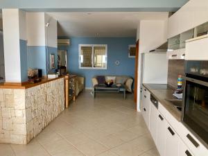 a kitchen with blue walls and a living room at Seaview Luxury Penthouse Mare in Sal Rei