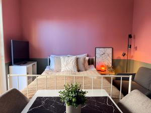 a bedroom with a bed with a pink wall at The Seabreeze Terrace Apartment in Turku