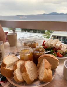 a plate of food with bread and jam and a salad at EMILIOS SEE VIEW in Barbati