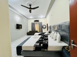a hotel room with two beds and a ceiling fan at Hotel Multan Avenue Multan in Multan