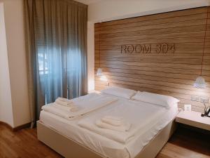 ein Schlafzimmer mit einem großen Bett mit hölzernem Kopfteil in der Unterkunft B612 in Levico Terme + 53 Fotos