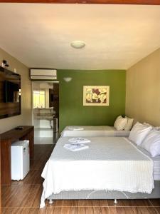 a bedroom with a large bed and a green wall at Estalagem do Carmo in Pirenópolis